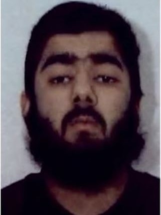 Mug shot of man with beard in front of grey background.