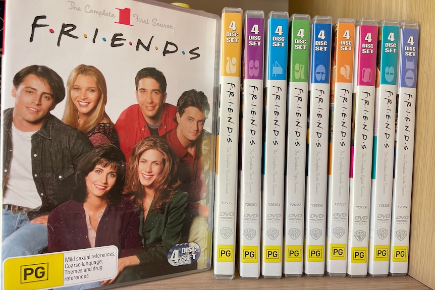 A collection of Friends DVDs displayed on a shelf 