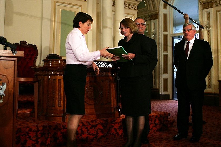 Cahtherine Holmes handing Anna Bligh the report. 