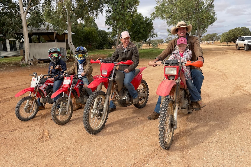 The McGlinchey family sit on motorbikes at Badalia Station in Channel Country