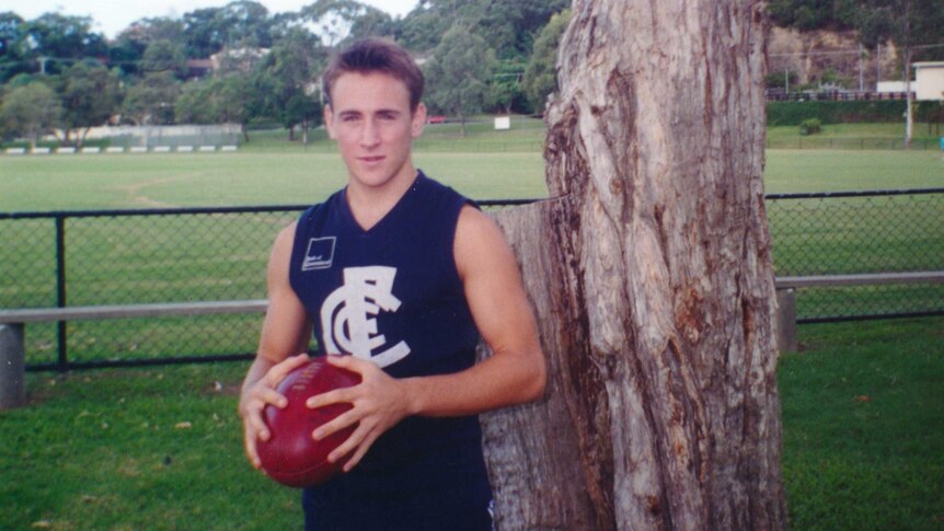 Bali bombing victim Billy Hardy poses with a football before a game.