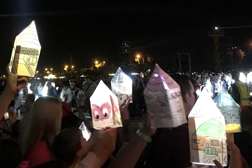 Five home-made paper lanterns with drawings on them held up by children at the PIA opening performance, 'Home'.