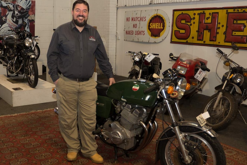 Auctioneer Adrian Cummings stands next to the Laverda 3C.