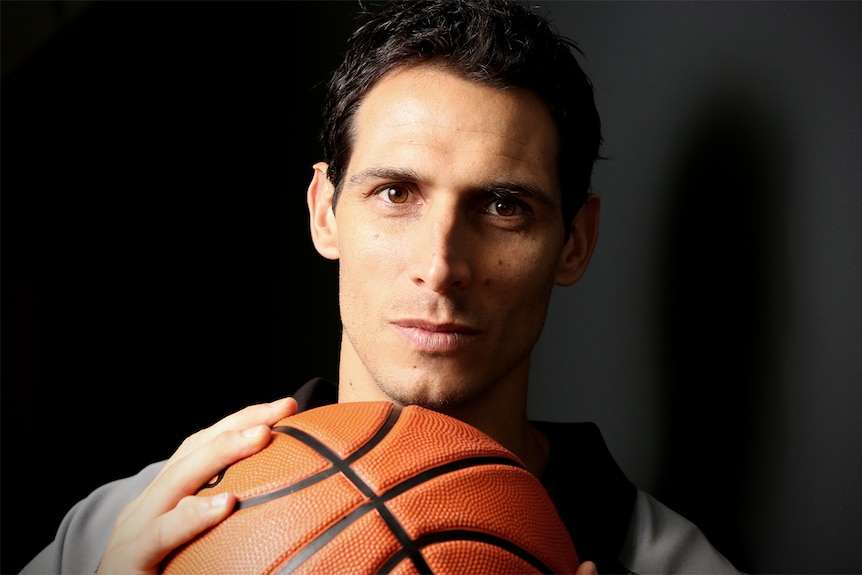 A tight headshot of Oscar Forman holding a basketball.