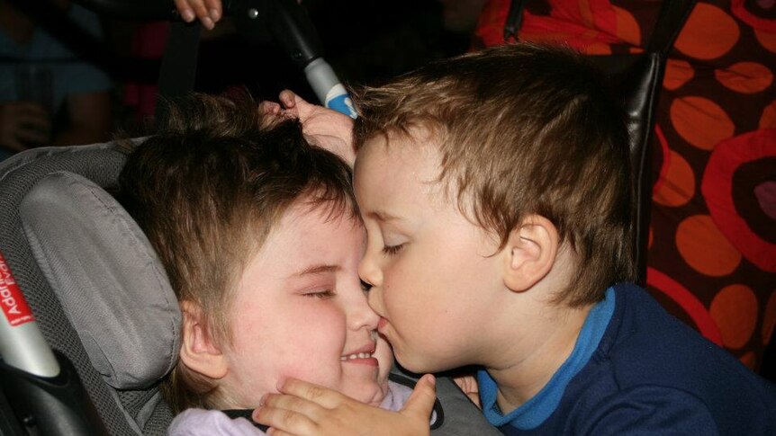 Colour photo of Adania and Redmond Evans kissing in car seat.