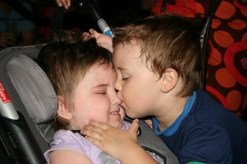 Colour photo of Adania and Redmond Evans kissing in car seat.
