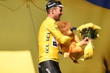 Early leader ... Mark Cavendish leaves the podium wearing the yellow jersey after winning the opening stage