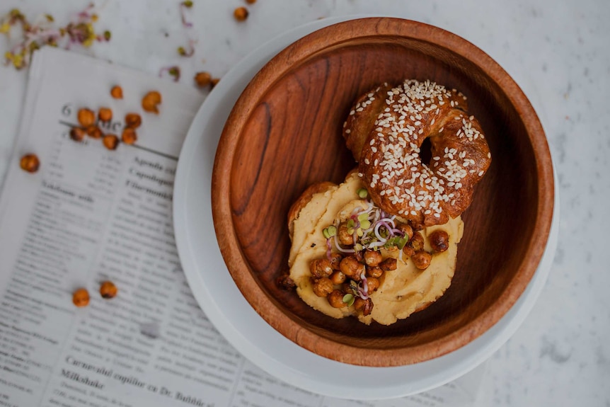 Hummus and chickpeas on a bagel.