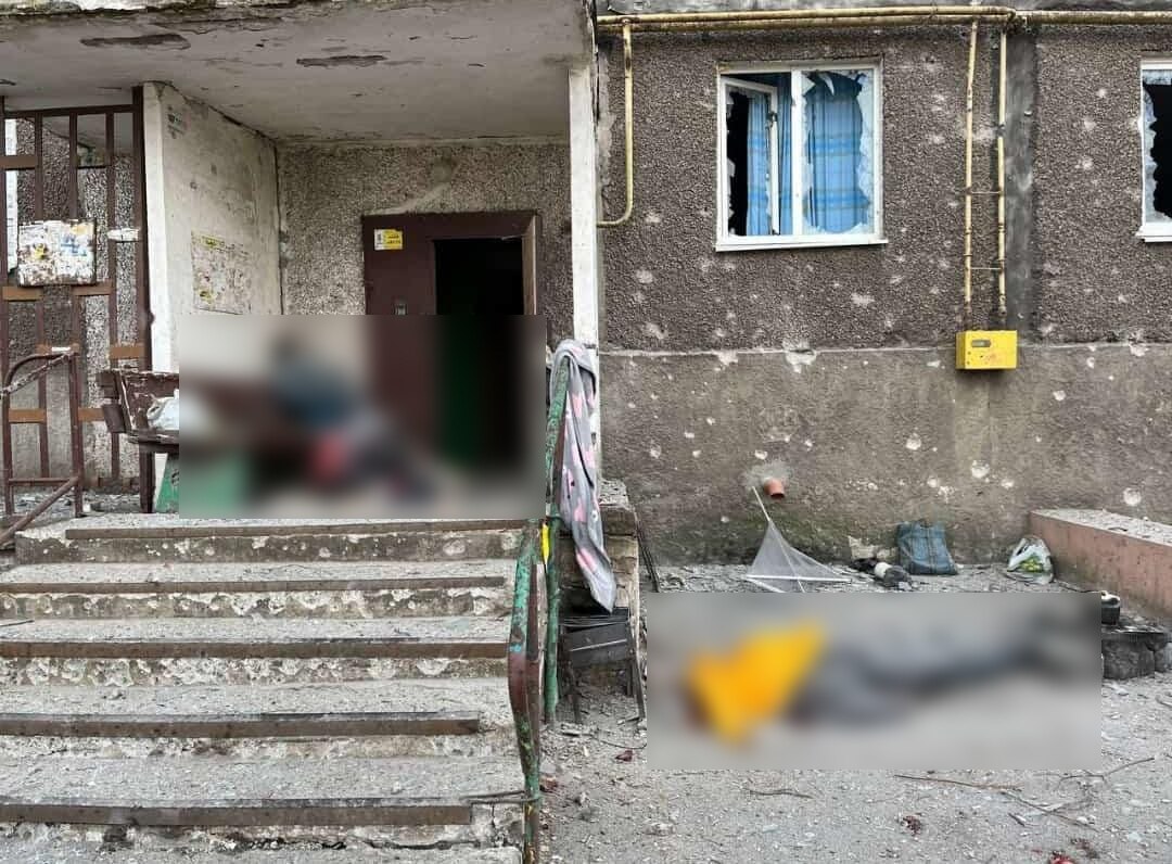 Two sections of the image are blurred as the content is extremely graphic. It's possible to see the ruins of the building. 