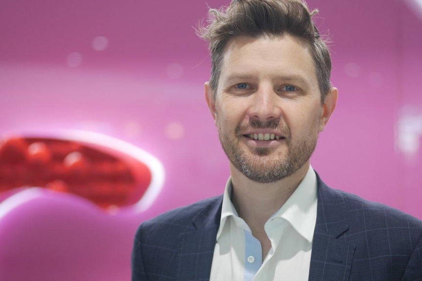 Caleb Jones standing in front of pink-coloured wall