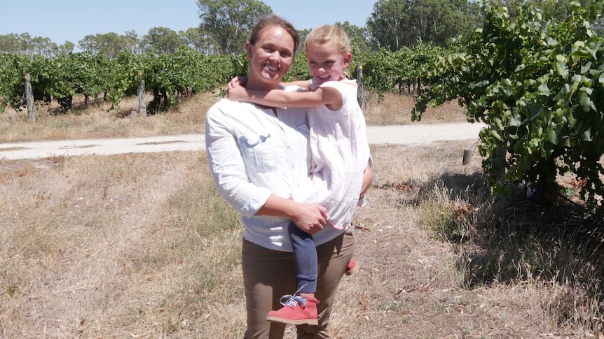 Padthaway vineyard owner Lissy Orton smiles while holding her daughter Daisy in her vineyard.