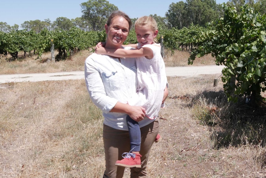 Padthaway vineyard owner Lissy Orton smiles while holding her daughter Daisy in her vineyard.