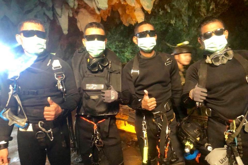 Thai Navy SEALs pose for a photo, making a thumbs up gesture.