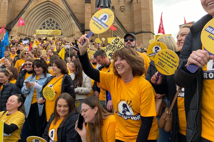 Women and men holding signs and smiling outside a church