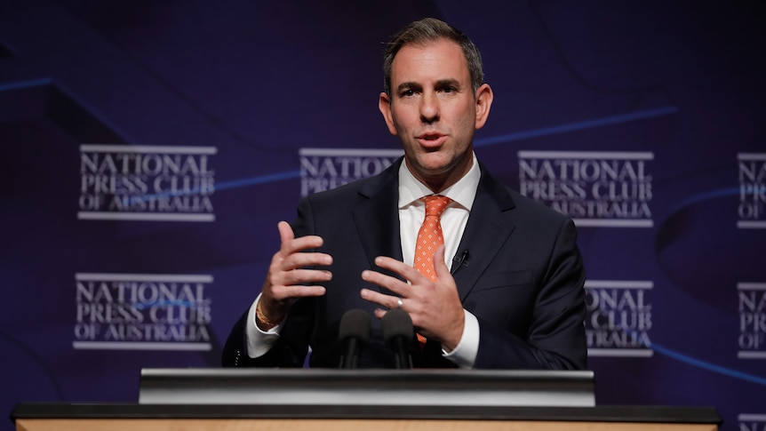 Jim gestures as he speaks at a podium.