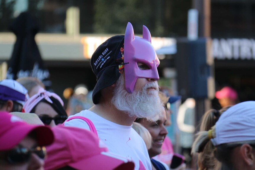 A man dressed in a pink Batman mask