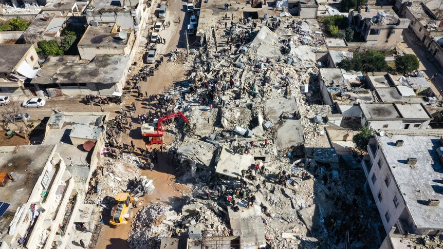 Rescue teams work to clear rubble in an aerial photo.