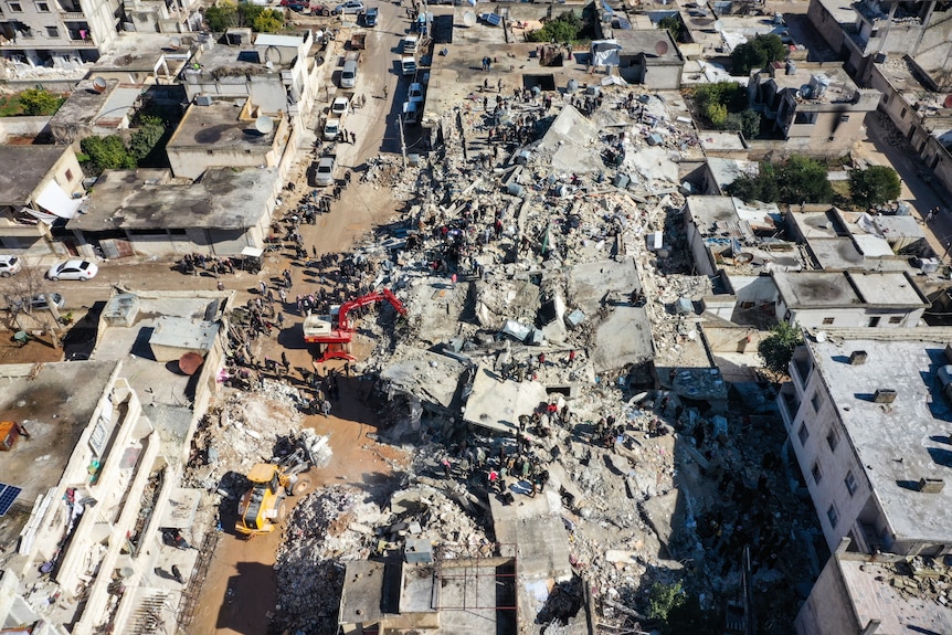 Rescue teams work to clear rubble in an aerial photo.