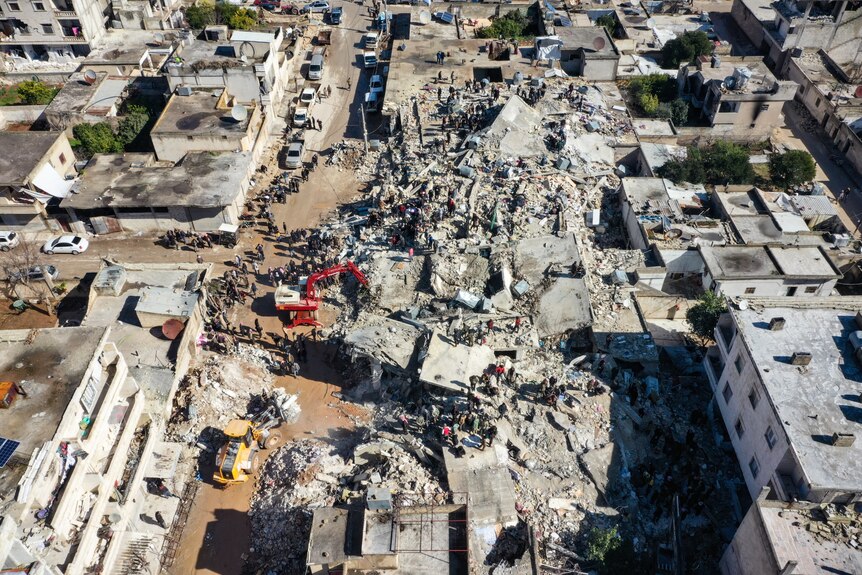 Rescue teams work to clear rubble in an aerial photo.