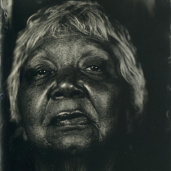 A black-and-white photographic portrait of an indigenous woman.