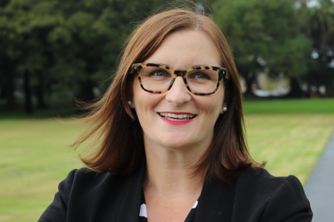 a woman wearing glasses smiling