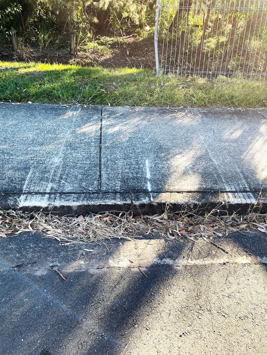 Tyre and car scrape marks, bent fence and tyre tracks into bush at side of road.