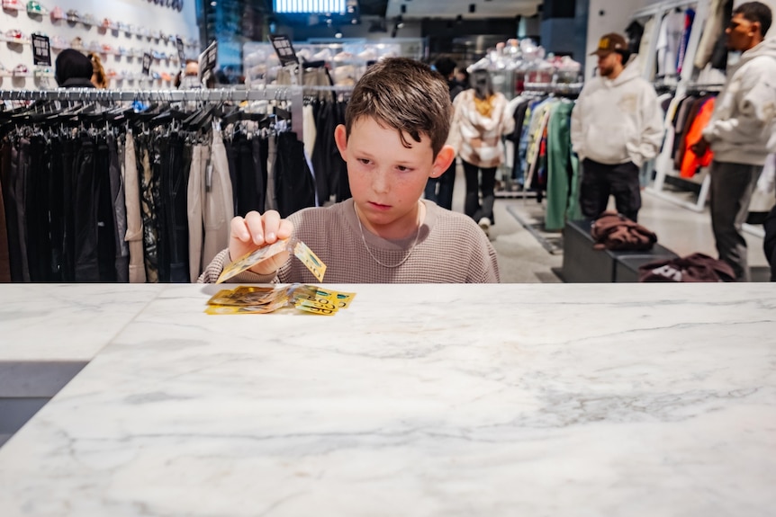 A photo of a kid counting money on the bench.