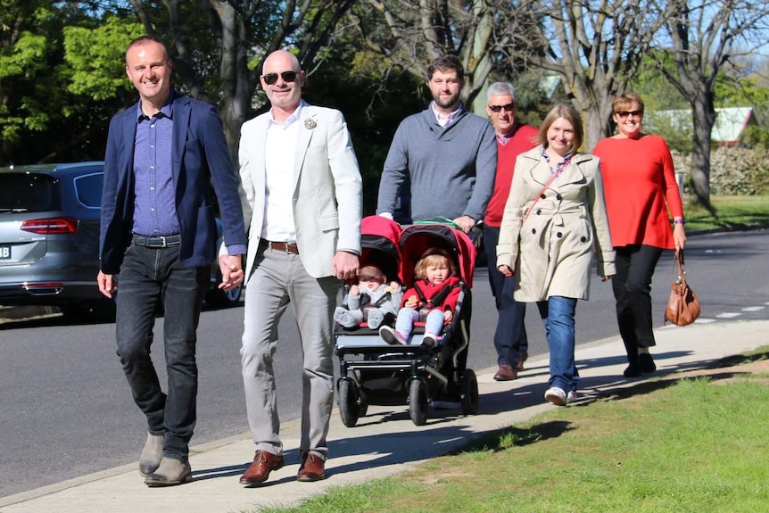 Chief Minister Andrew Barr walks hand-in-hand with his partner to vote at Ainslie Primary in the 2016 ACT Election.