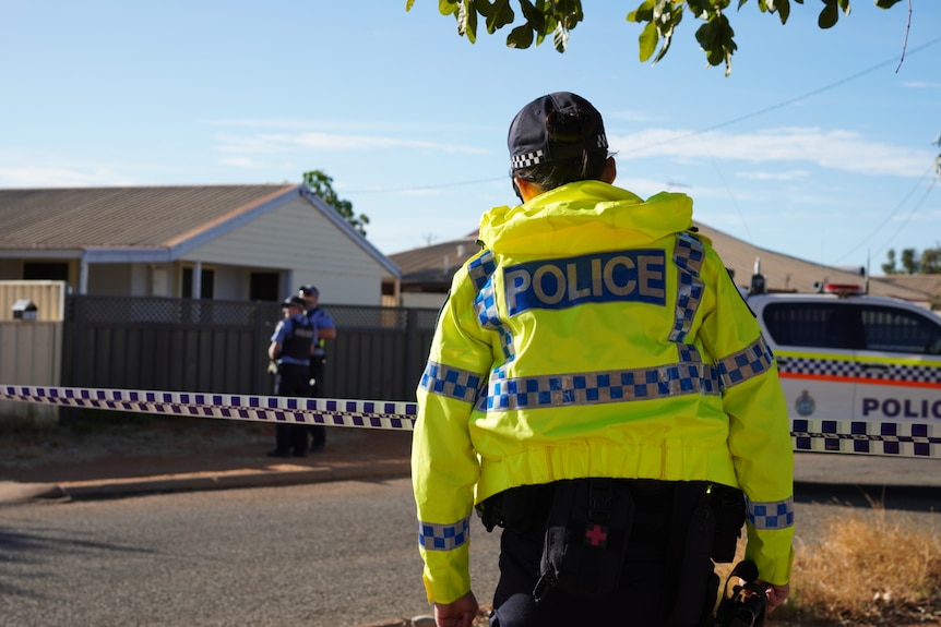 Police in high-vis in front of a suburban home