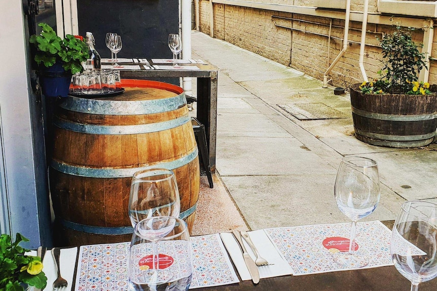A laneway with tables and wine glasses outdoor