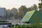 Debris: rubbish and cargo containers lie strewn across Blunder Road at Oxley