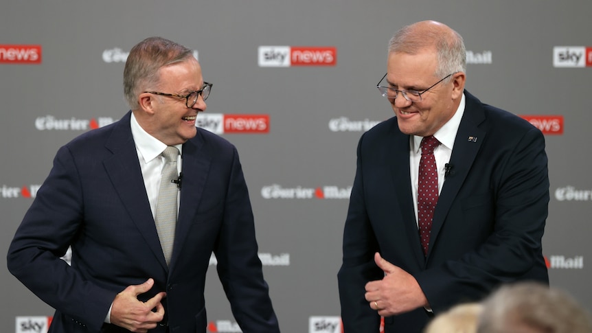 Albanese straights his jacket while laughing, Morrison pulls an awkward thumbs up