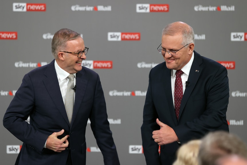 Albanese straights his jacket while laughing, Morrison pulls an awkward thumbs up