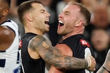 Tom Mitchell and Jamie Elliott hug and smile after a goal