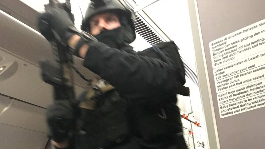 A heavily armed police officer is seen onboard a Malaysia Airlines plane.