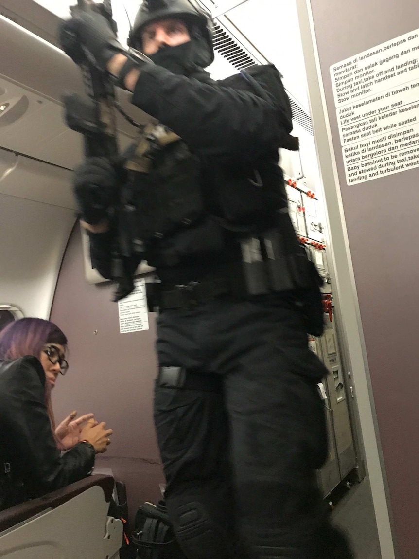 A heavily armed police officer is seen onboard a Malaysia Airlines plane.