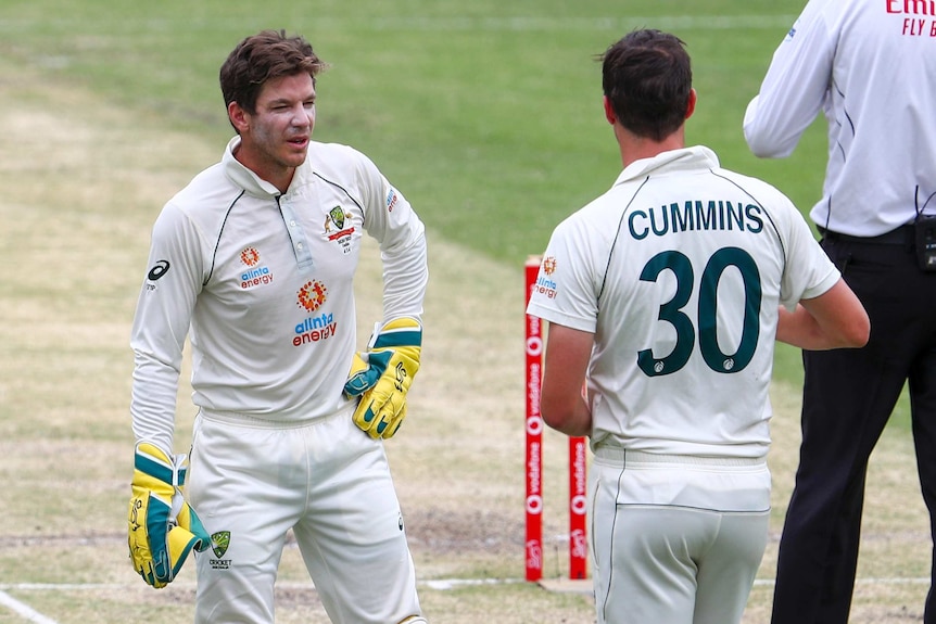Australia wicketkeeper Tim Paine speaks to bowler Pat Cummins on the field during a Test at the Gabba.