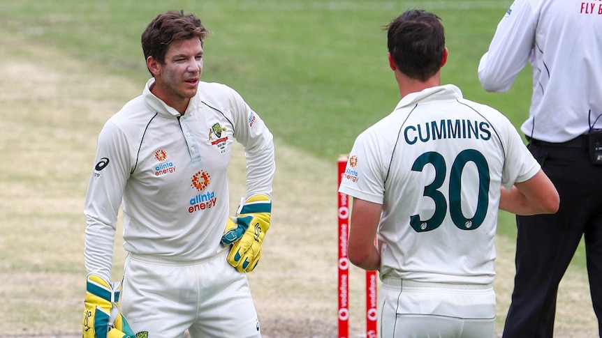 Australia wicketkeeper Tim Paine speaks to bowler Pat Cummins on the field during a Test at the Gabba.