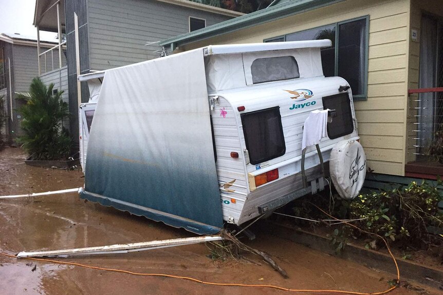 A damaged caravan leaning against other annexes at a flooded caravan park in Cairns in far north Queensland on March 27, 2018