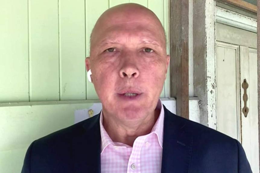 Home Affairs Minister Peter Dutton standing inside an old timber Queenslander house