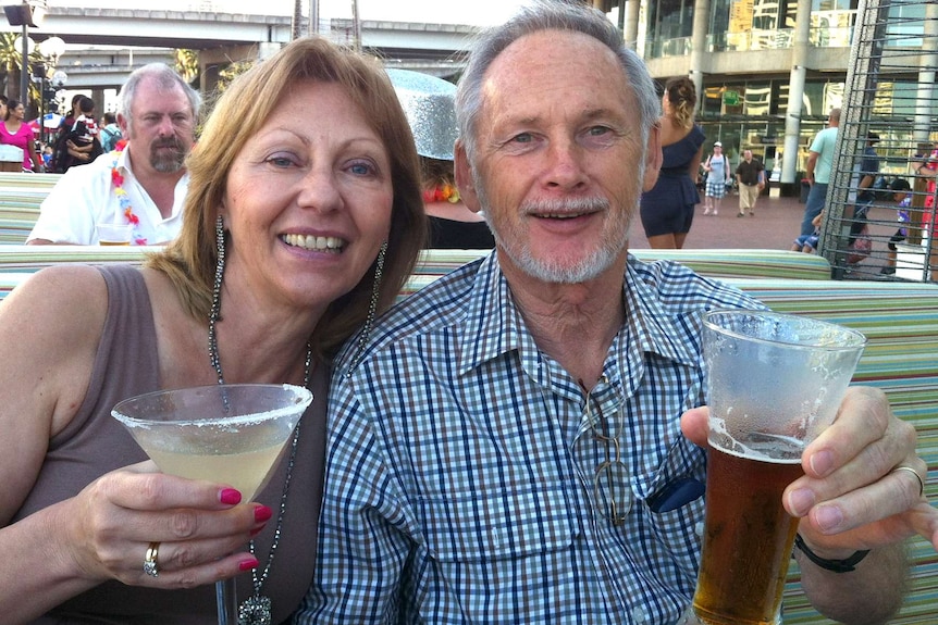 Mr Reeves and his wife hold up a beer and margarita, toasting the photographer, sitting outside on a bench.