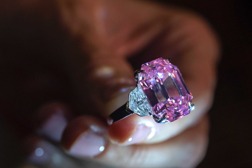 A Christie's employee displays the 18.96-carat fancy vivid pink diamond.