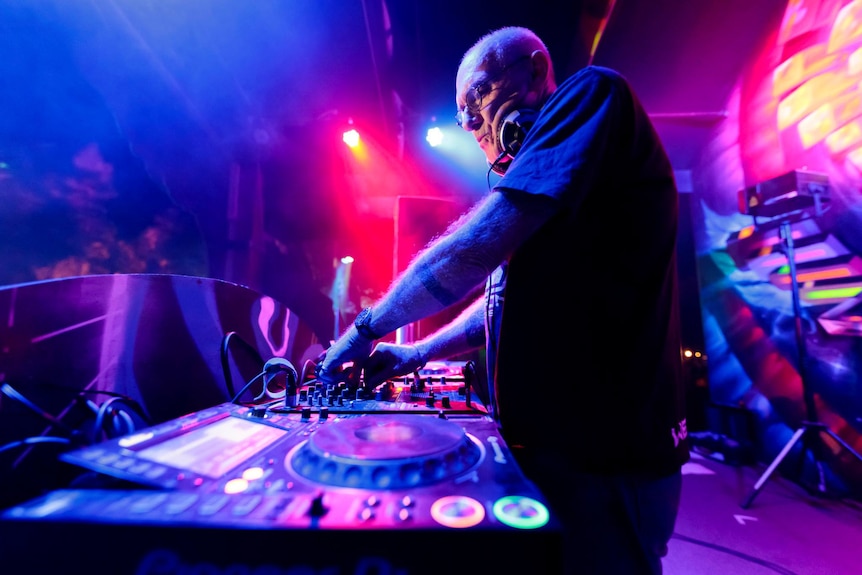Photo of older man with glasses DJing.