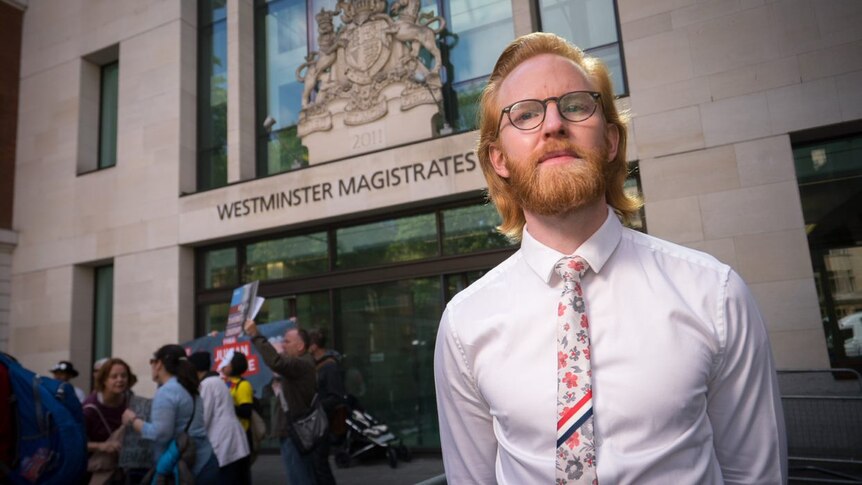 WikiLeaks ambassador Joseph A Farrell, has red hair, glasses, and wears a white shirt with floral tie outside court.