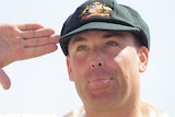 Shane Warne salutes while poking out his ton and wearing his baggy green