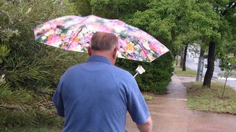 Man walking with umbrella in rain.