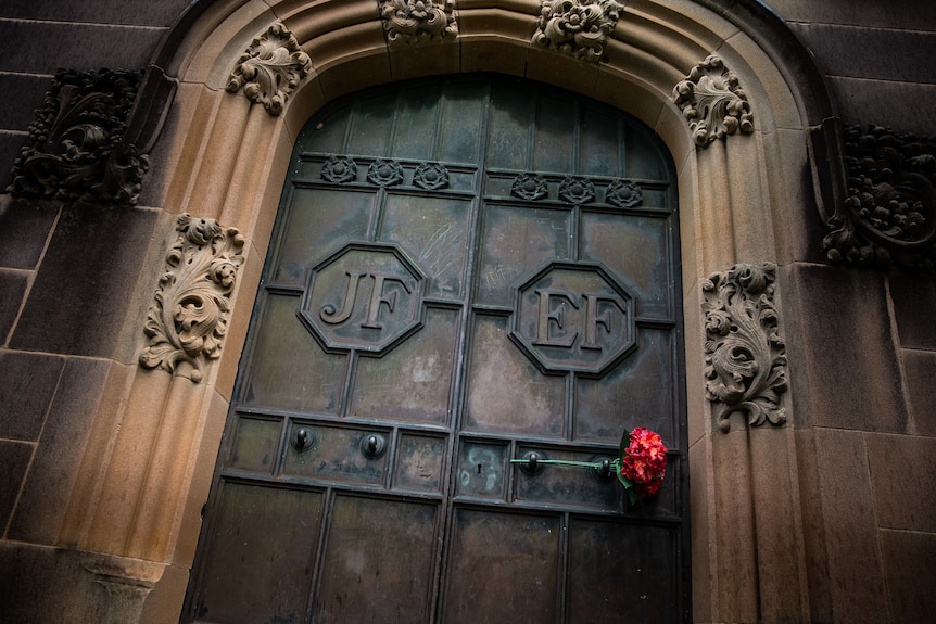 Heavy metal doors with the initials JF and EF and a rose threaded through.
