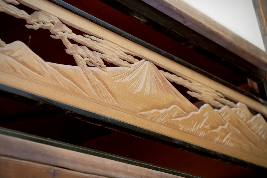 A wooden carving of a mountain and clouds