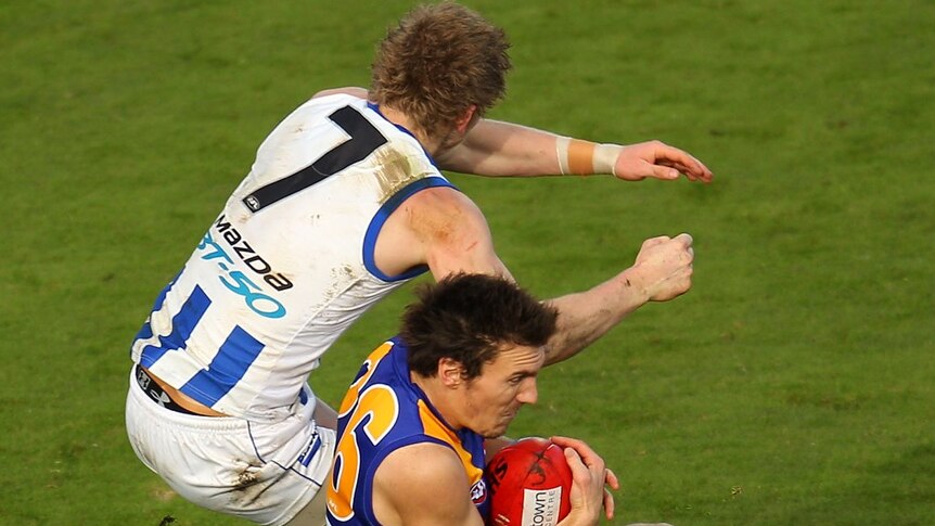 The Eagles' Sam Butler pays for his mark over North Melbourne's Jack Ziebell.