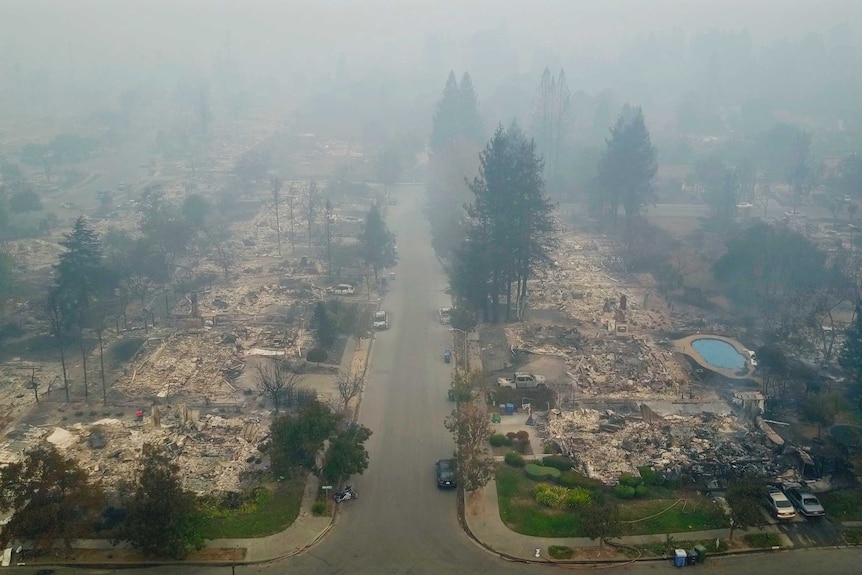 An aerial photograph shows smoke billowing over destroyed homes in Santa Rosa.